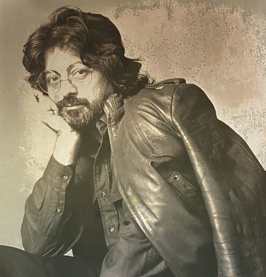 A black and white photo of a man in a leather jacket.