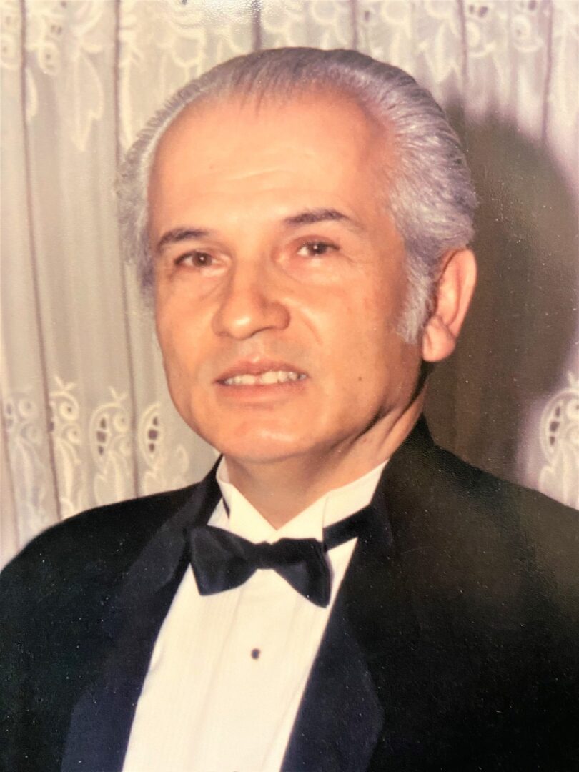A man in a tuxedo posing for a photo.