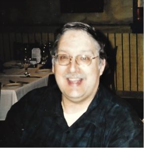 A man smiling at a table in a restaurant.