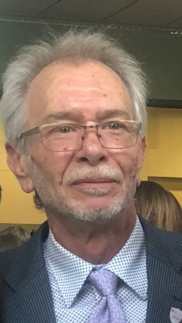 An older man in a suit and tie.