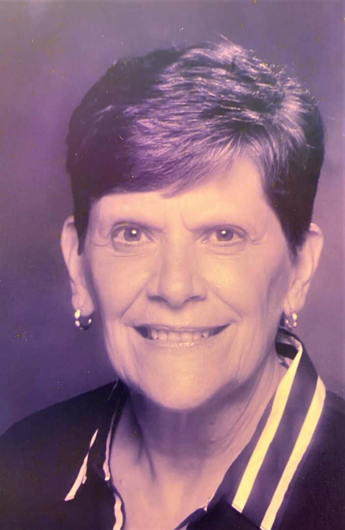 A black and white photo of an older woman smiling.