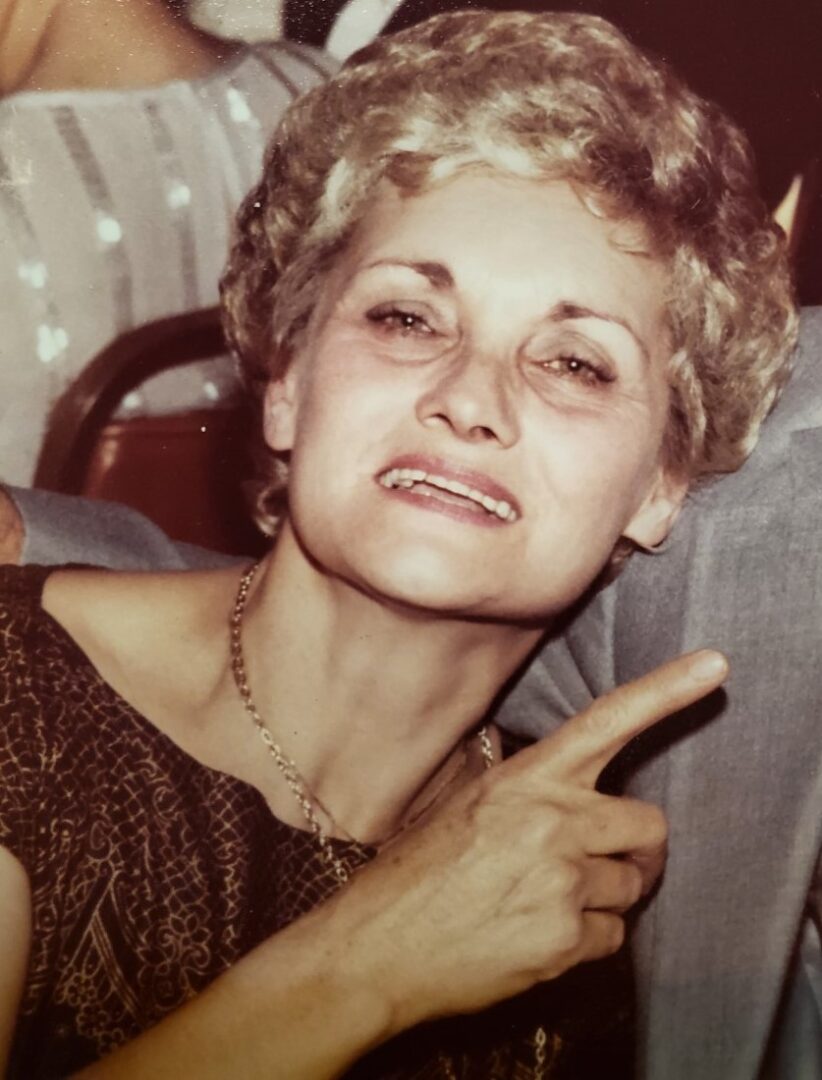 A woman is posing for a picture with her finger up.