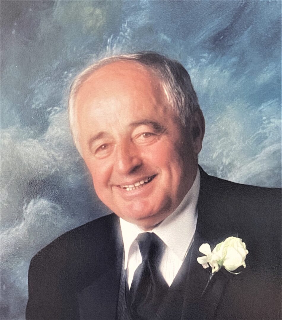 A man in a suit and tie smiles for the camera.