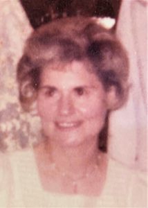 An old photo of a woman in a white dress.