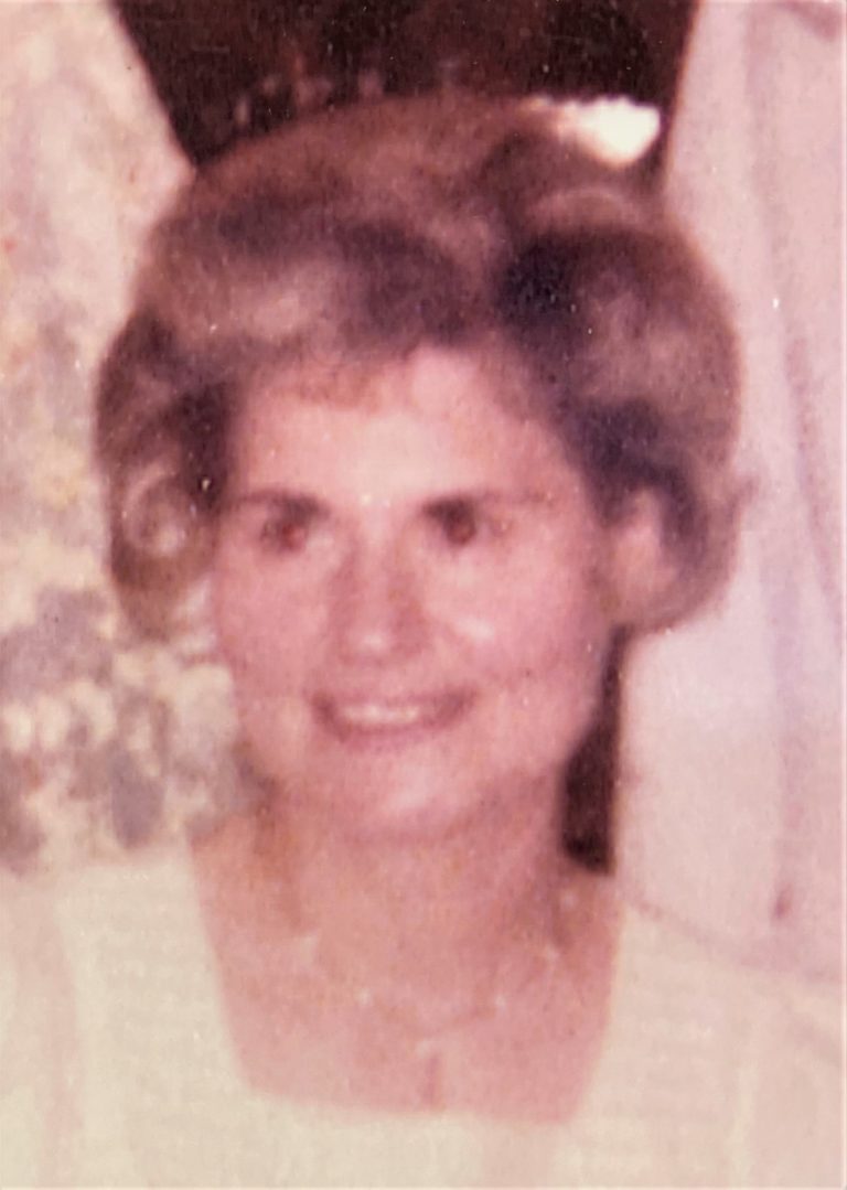 An old photo of a woman in a white dress.