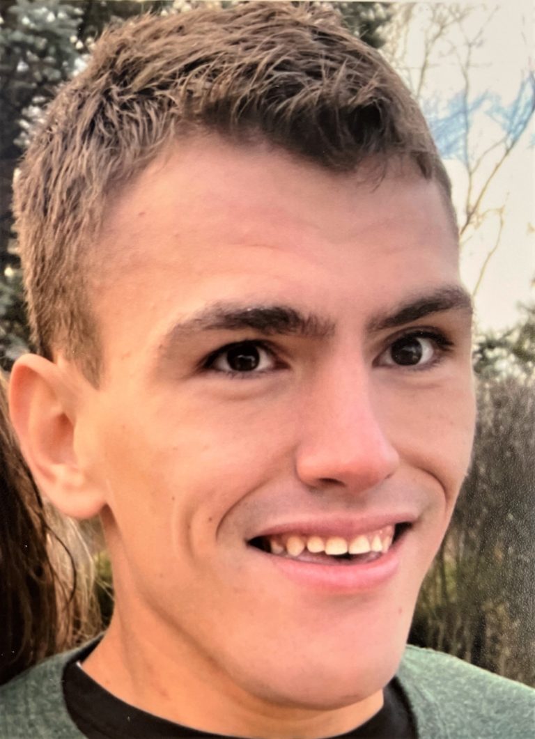 A young man is smiling for the camera.