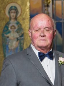 An older man in a suit and bow tie.