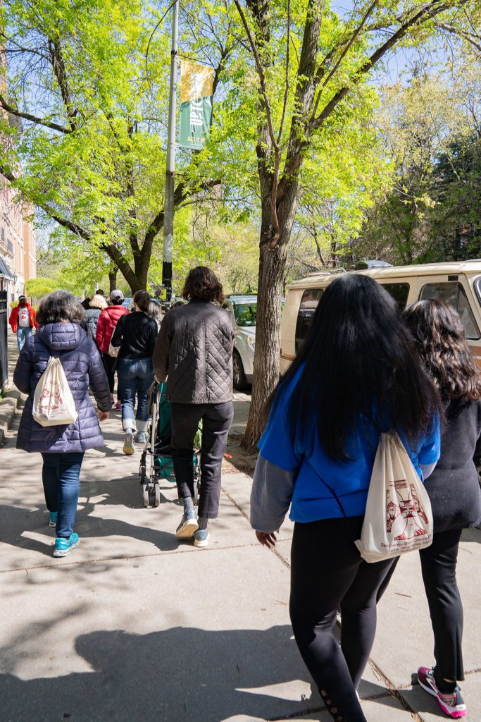 A group of people walking down a sidewalk.