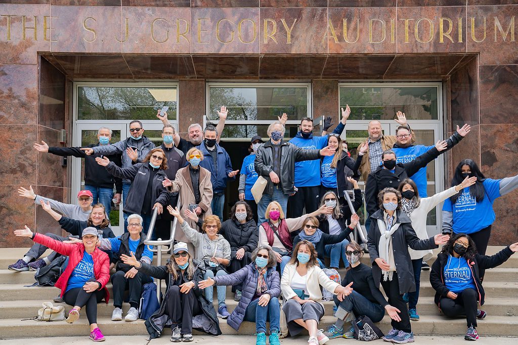 A group of people posing in front of a building.