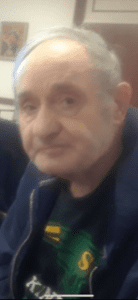An older man is sitting in a chair.