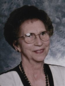 An older woman wearing glasses and a necklace.