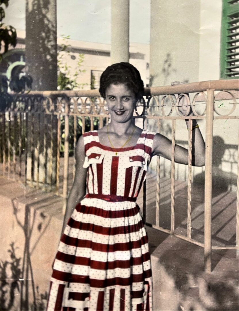 An old photo of a woman in a red and white striped dress.