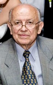 An older man in a suit and tie posing for a photo.