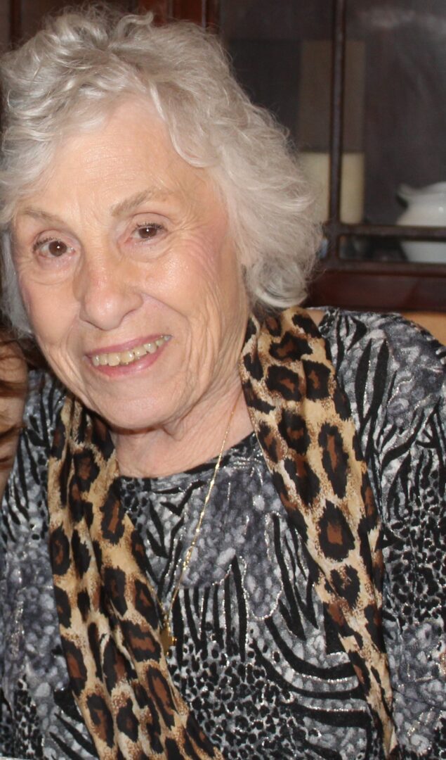 An older woman with a leopard print scarf.