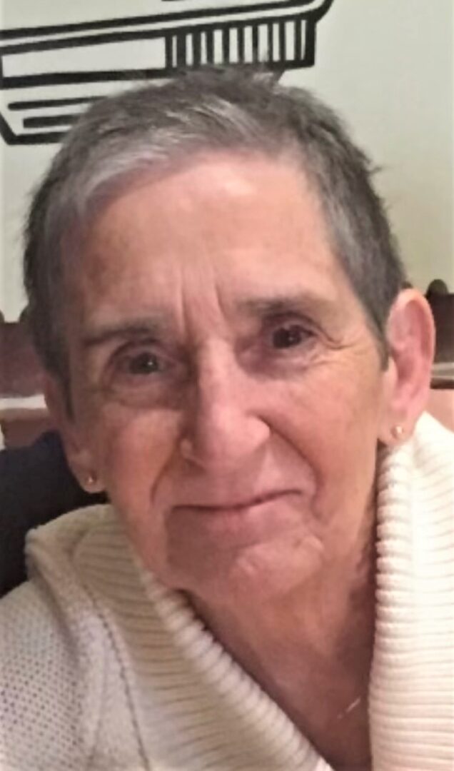 An older woman is smiling for the camera.