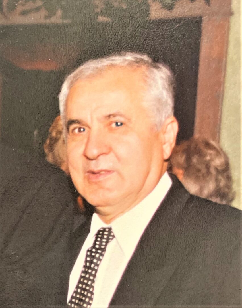 A man in a suit and tie is posing for a photo.