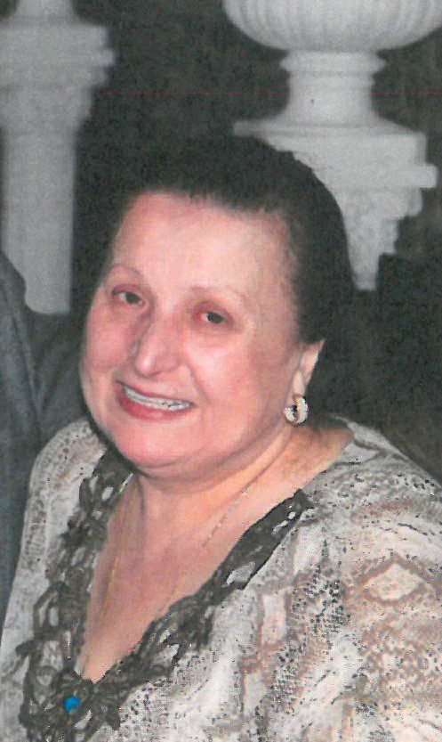 An older woman is smiling for the camera.