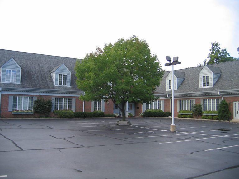A parking lot in front of a brick building.