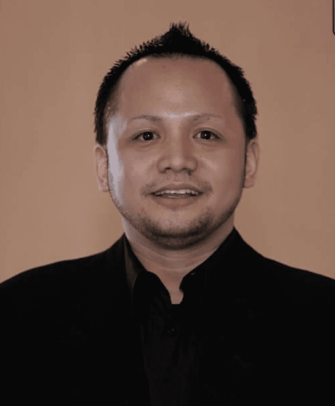 A man wearing a black shirt and black jacket.