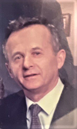 A man in a suit and tie is posing for a photo.