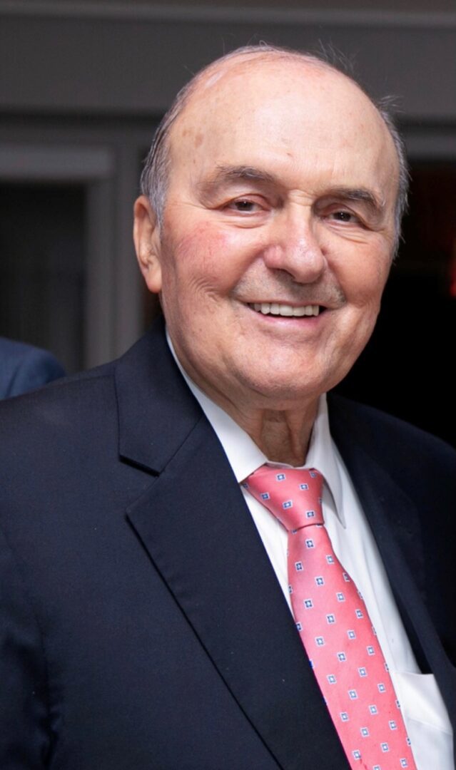 A man in a suit and tie smiles for the camera.