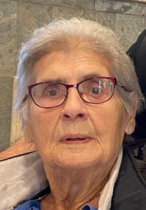 An older woman in a wheelchair looking at the camera.