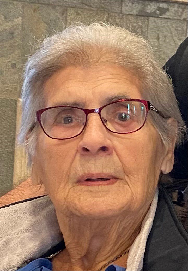 An older woman in a wheelchair looking at the camera.