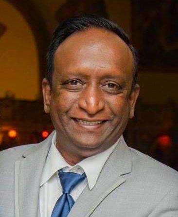 A man in a suit and tie smiles for the camera.