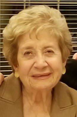 An older woman is posing for a photo.