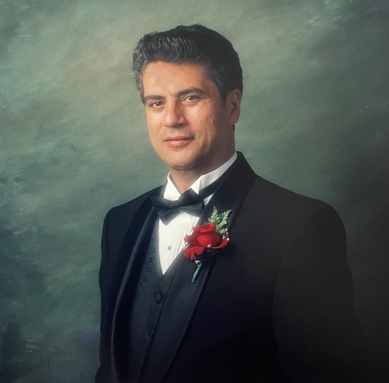 A man in a tuxedo posing for a portrait.