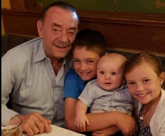 A man and two children posing for a photo at a restaurant.