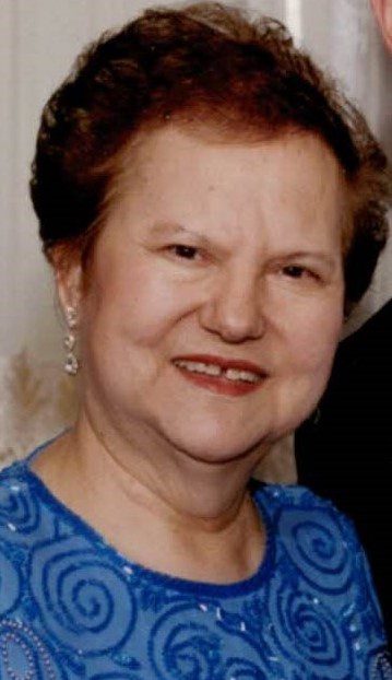 A woman in a blue dress is posing for a picture.