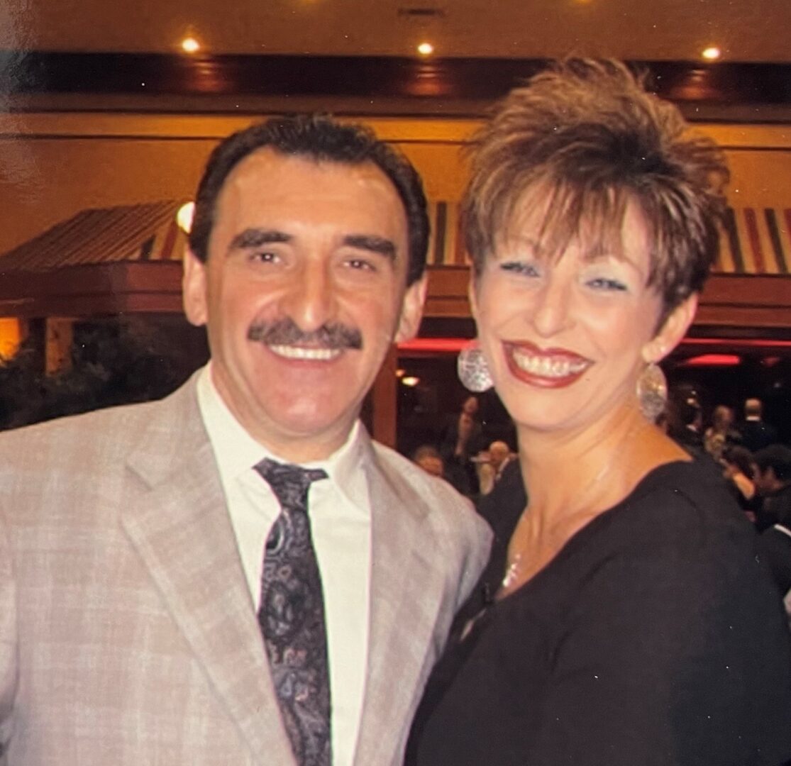 A man and woman posing for a photo in a formal setting.