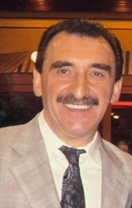 A man in a suit with a mustache.