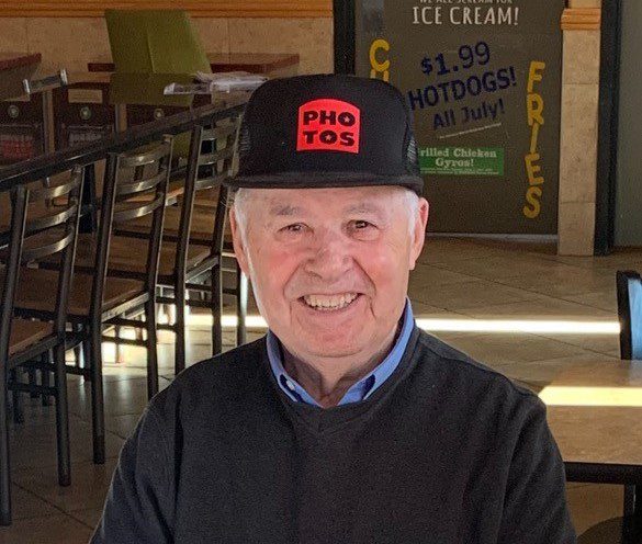 An older man wearing a hat in a restaurant.