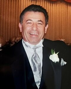 A man in a tuxedo smiling for the camera.