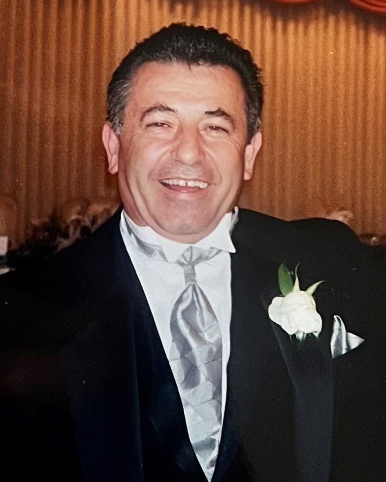 A man in a tuxedo smiling for the camera.