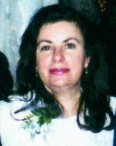 A woman in a white dress is posing for a picture.
