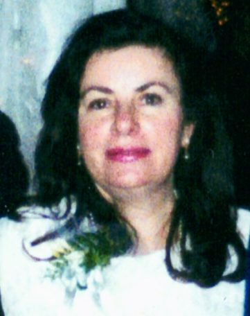A woman in a white dress is posing for a picture.