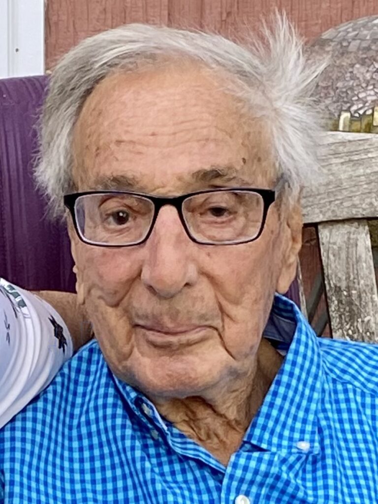 An older man with glasses is sitting next to a younger man.