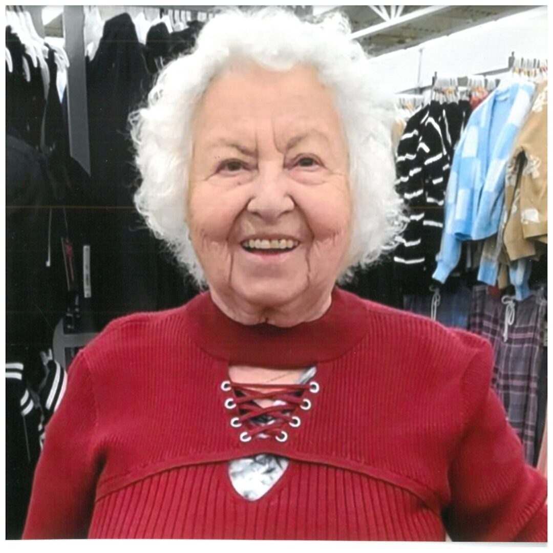 Lilly Kretsos, an older woman, smiling in a clothing store.