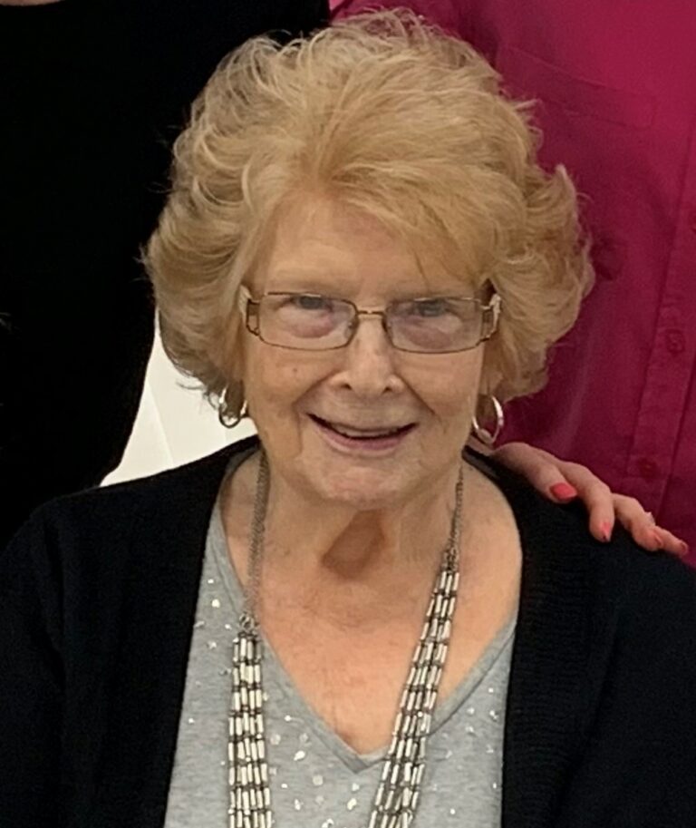 Lilly Kretsos, an older woman, is posing for a photo with her friends.