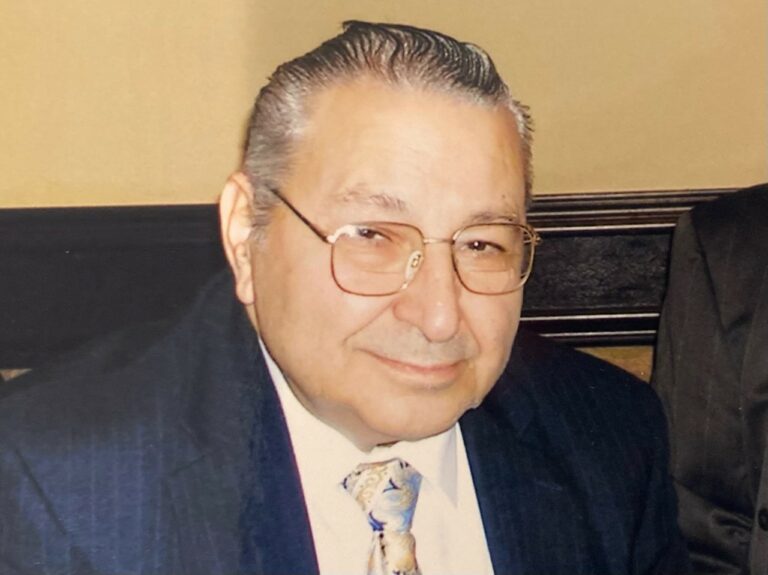 Lilly Kretsos, a man in a suit and tie, is posing for a photo.