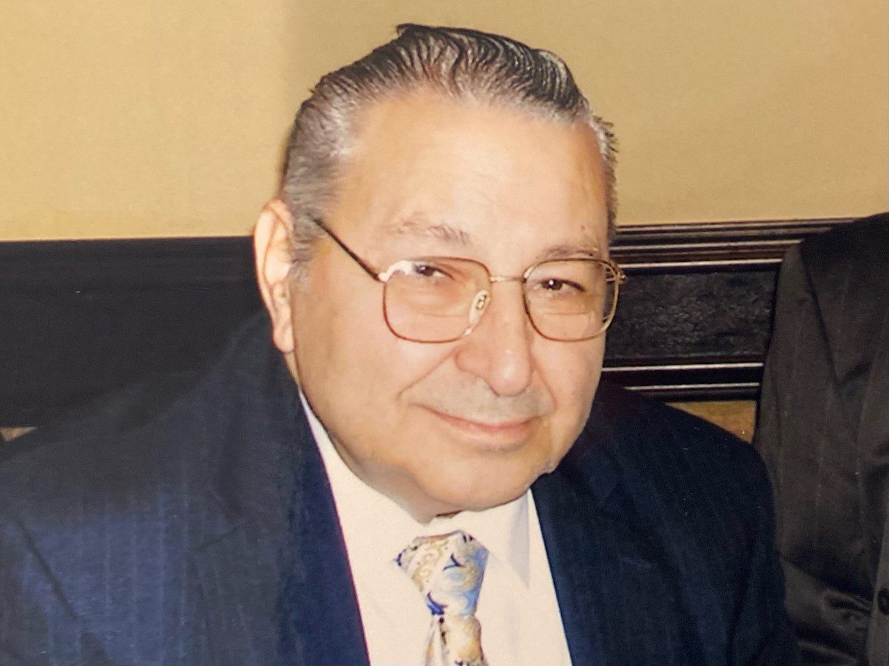 Lilly Kretsos, a man in a suit and tie, is posing for a photo.