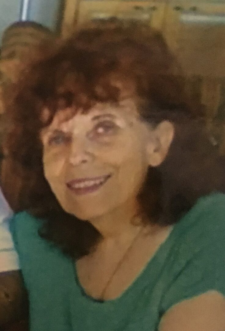 An older woman named Lilly Kretsos is smiling for the camera.