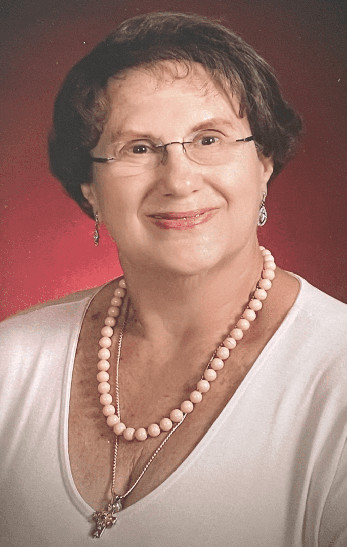 Helen Karkazis, an older woman wearing glasses and pearls.