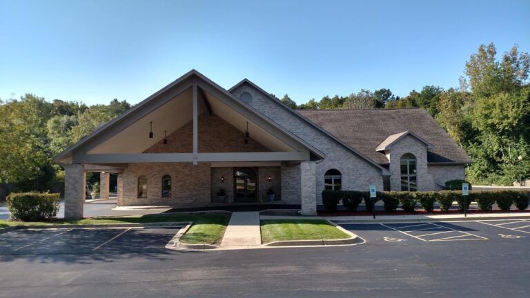 The front of a church in a parking lot.