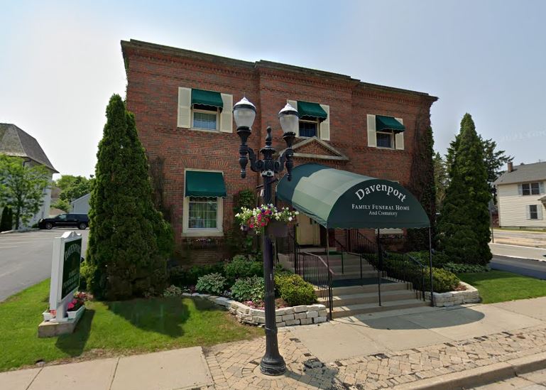 The front of a brick building with a green awning.