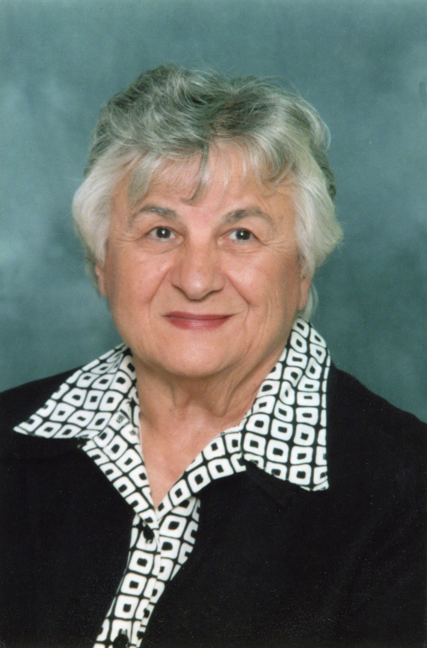 An old lady wearing a checked shirt and a black coat