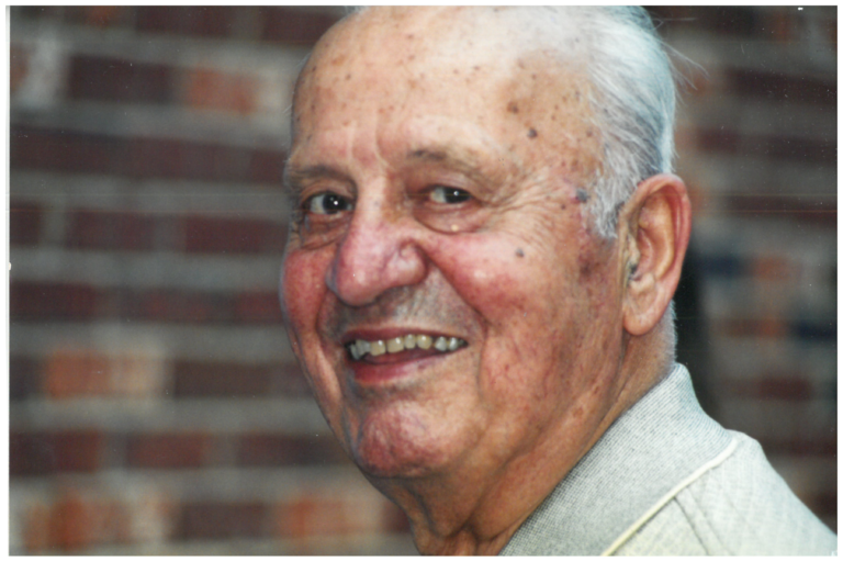 An old man with wrinkles on face smiling at the camera